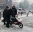7日，沈阳市和平区，一名电动车驾驶者在路上滑倒后站起。　张颖 摄 - 新浪辽宁